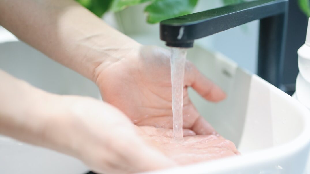 Kobieta myje ręce nad umywalką w łazience